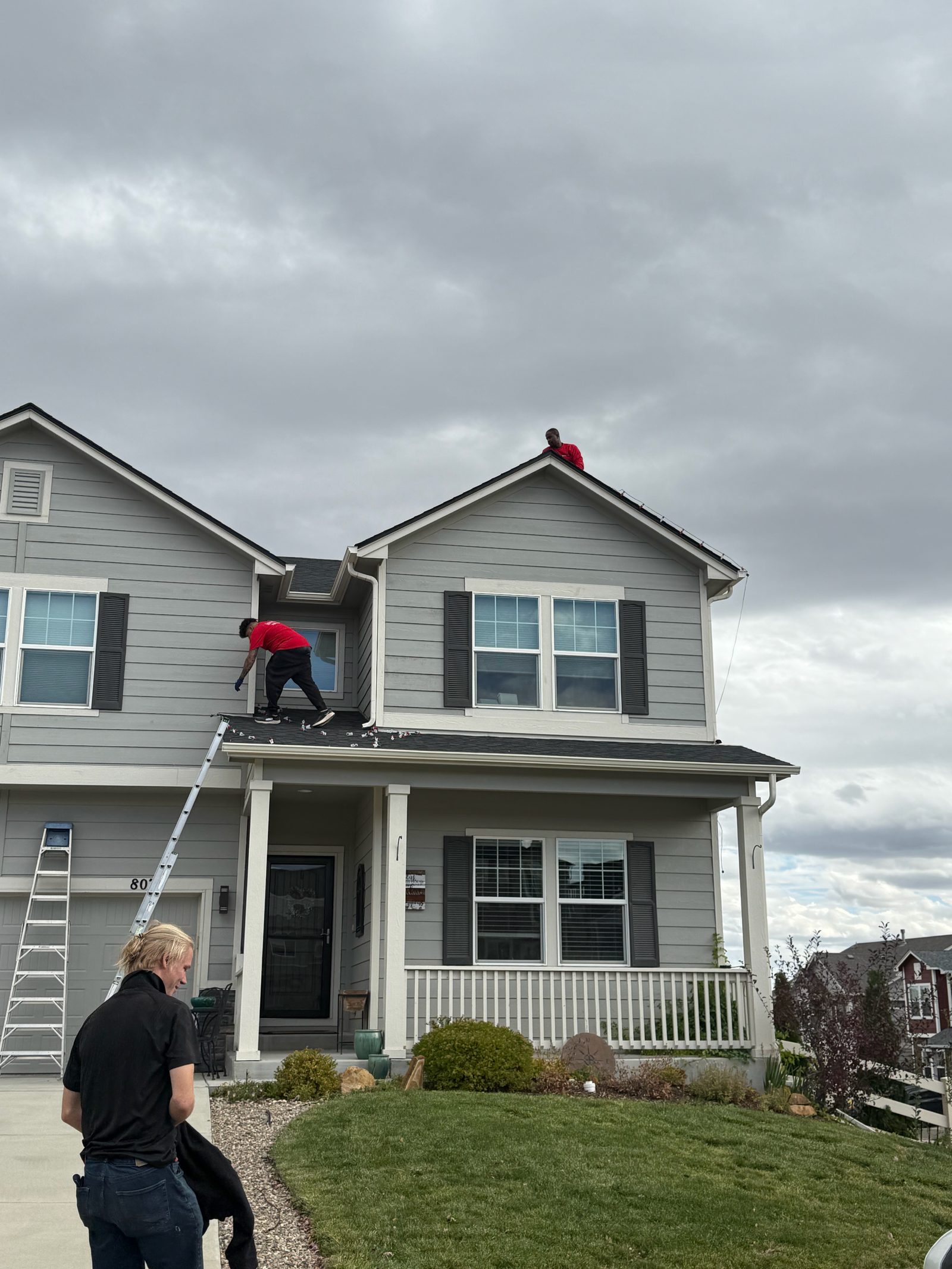 Our crew installing warm white C9 Christmas lights on a two-story home roofline